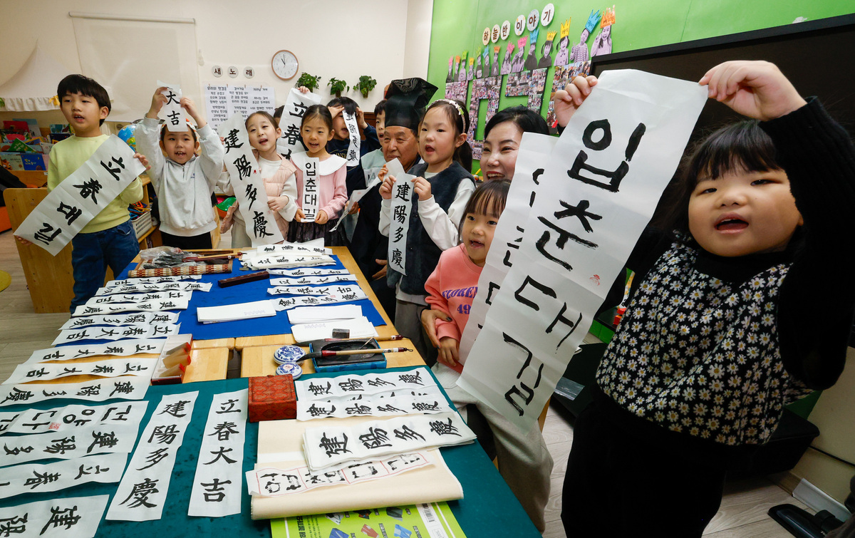 입춘을 하루 앞둔 3일 서울 송파구청 어린이집에서 어린이들이 입춘첩을 들고 기념사진을 찍고 있다. 이날 송파서화협회 서예가들은 어린이집을 방문해 입춘을 상징하는 글귀인 ‘입춘대길(立春大吉)’, ‘건양다경(建陽多慶)’을 소개하고 직접 써보도록 지도했다.